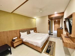 a bedroom with a bed and a flat screen tv at Hotel ROCKBAY, Puri Swimming-pool, near-sea-beach-and-temple fully-air-conditioned-hotel with-lift-and-parking-facility in Puri