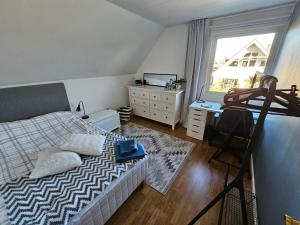 a bedroom with a bed and a dresser and a window at Part of a luxury villa with private facilities in Åkarp