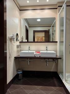 a bathroom with two sinks and a mirror at LA CANTUEÑA in Madrid