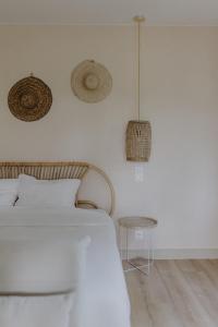 a white bedroom with a bed and a table at Côte & Lodge in Talais