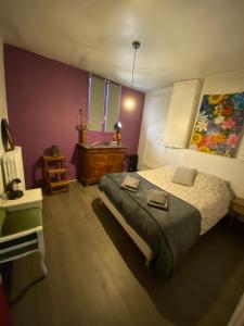 1 dormitorio con 1 cama y una pintura en la pared en COSY B&B en Murat