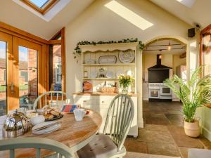 a kitchen with a wooden table and chairs at 4 Bed in Blakeney 90589 in Awre