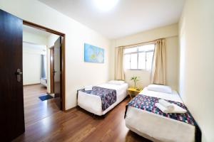 a hotel room with two beds and a window at Itapetinga Hotel in Atibaia