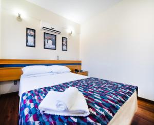 a bedroom with a bed with towels on it at Itapetinga Hotel in Atibaia