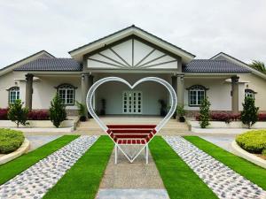 une maison avec un siège cardiaque devant elle dans l'établissement Villa Dracaena Melaka - Private Pool, Hill View, 20 minutes to Town, à Kampong Bukit Katil