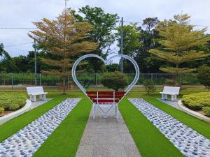 a heart sculpture in a park with two benches at Villa Dracaena Melaka - Private Pool, Hill View, 20 minutes to Town in Kampong Bukit Katil