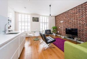 倫敦的住宿－Welcome London - Drury Lane，厨房以及带砖墙的起居室。