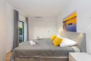 een slaapkamer met een groot bed met gele kussens bij Villa Impression by Istrialux in Ližnjan