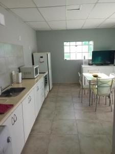 a kitchen with a table and a refrigerator at Lupita 3 in General Roca