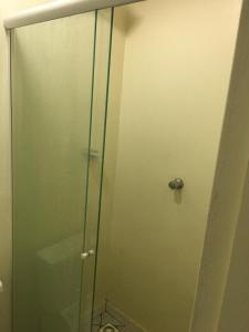 a shower with a glass door in a bathroom at Loft confortável no Centro in Chapecó