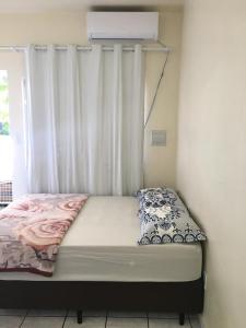 uma cama num quarto com uma janela com aversão em Loft confortável no Centro em Chapecó