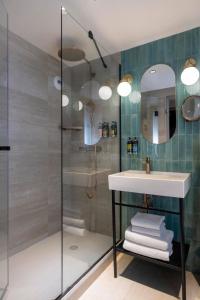a bathroom with a sink and a shower at H&ocirc;tel Maxim Op&eacute;ra in Paris