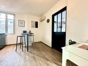 una sala de estar con una puerta negra y una mesa en LE SAINT ROCH - Hyper Centre, en Mont-de-Marsan