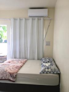 uma cama num quarto com uma janela em Loft confortável no Centro em Chapecó