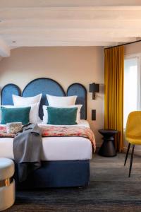 une chambre avec un grand lit avec une tête de lit bleue dans l'établissement Hôtel Maxim Opéra, à Paris