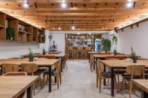 restauracja z drewnianymi sufitami, stołami i krzesłami w obiekcie Villa Falcons Nest w mieście Gračac