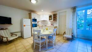 eine Küche mit Tisch und Stühlen und einem Kühlschrank in der Unterkunft Villa en plein centre du village, de plain pied et rénovée en 2008 in Saint-Martin-de-Ré