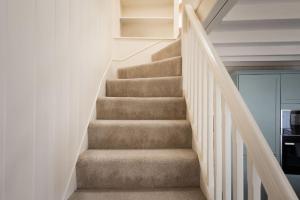 a staircase in a home with white walls at White House, Port Isaac Bay Holidays in Port Isaac