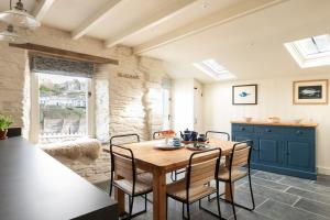 a dining room with a wooden table and chairs at White House, Port Isaac Bay Holidays in Port Isaac