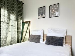 1 dormitorio con 1 cama con 2 almohadas y ventana en LE SAINT ROCH - Hyper Centre, en Mont-de-Marsan