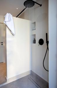 pared blanca con ducha en una habitación en Theros Estate, en Anfiloquía