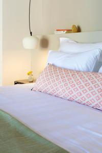 1 cama con sábanas blancas y manta roja y blanca en Theros Estate, en Anfiloquía