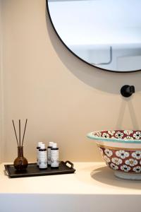 - un comptoir avec un bol, un lavabo et un miroir dans l'établissement Theros Estate, à Amphilochie