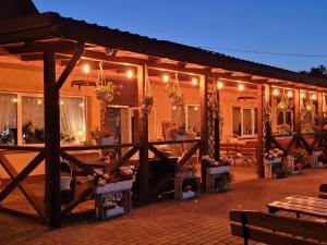 a building with a patio with tables and flowers at Zajazd na Liwskich Mostach in Węgrów