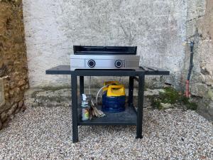 una estufa en una mesa junto a una pared en le Domaine du Trouiller, en Cendrieux