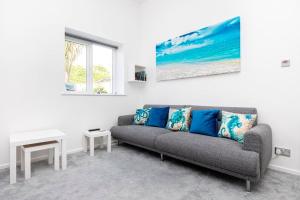 a living room with a couch and a painting on the wall at Bournecoast: Patio Garden - Parking - WIFI -FM8455 in Bournemouth