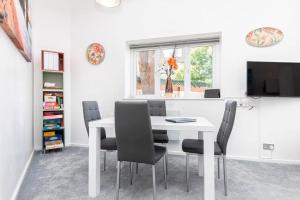 a white dining room with a white table and chairs at Bournecoast: Patio Garden - Parking - WIFI -FM8455 in Bournemouth