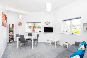 a living room with a couch and a dining room table at Bournecoast: Patio Garden - Parking - WIFI -FM8455 in Bournemouth