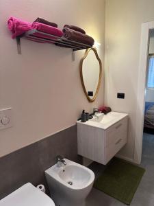Un baño con lavabo, inodoro y espejo. en Alloggio con Terrazza, en Villanova Mondovì 15 fotos más