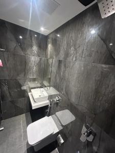 een badkamer met een wastafel, een toilet en een spiegel bij MIG SUITES in Mumbai