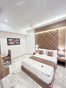 een slaapkamer met een groot bed en een stoel bij MIG SUITES in Mumbai