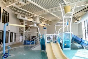 a indoor pool with a water slide in a building at 246, Belle Aire, Hemsby - Beautifully presented two bed chalet, sleeps 5, pet friendly, close to beach! in Great Yarmouth