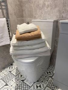 a pile of towels sitting on top of a toilet in a bathroom at Elegant home near Stratford upon avon in Alcester