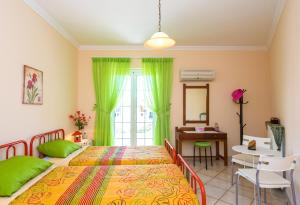 a bedroom with two beds and a table and a desk at House of Velenia, Family Apt 15' from Corfu center in Corfu
