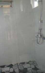 Baño blanco con ducha y ventana en Nhật Hạ Villa en Tam Hà
