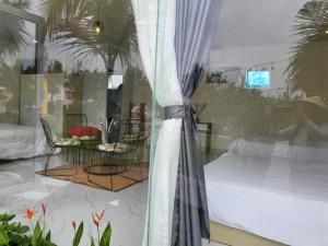 um reflexo de um quarto com uma mesa e cadeiras numa janela em Nhật Hạ Villa em Tam Hà