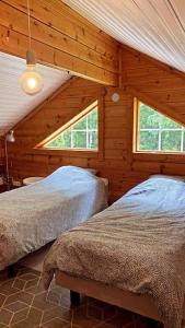 a bedroom with two beds in a wooden cabin at Upea villa lähellä rantaa poreallas & SUP-laudat in Vaasa