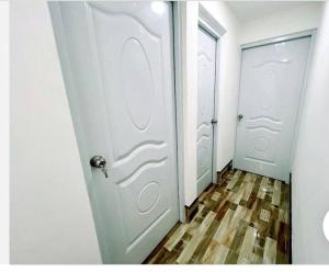 a hallway with two white doors and a wooden floor at JC caribe Aparta Hotel #7 in Boca Chica