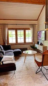 a living room with a couch and a table at Upea villa lähellä rantaa poreallas & SUP-laudat in Vaasa