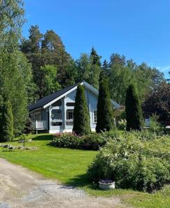 a house with a yard with trees and a driveway at Upea villa lähellä rantaa poreallas & SUP-laudat in Vaasa