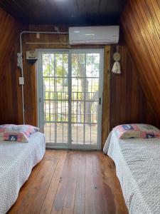 a room with two beds and a large window at La alpina playa nebel in Concordia