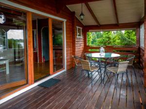 a wooden deck with a table and chairs on it at Domki Kątno in Stare Jabłonki +51 photos