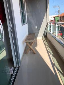 een houten bank aan de zijkant van een balkon bij Casa e suítes da Vava in Trairi