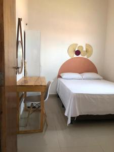 een slaapkamer met een bed en een tafel met een tafel bij Casa e suítes da Vava in Trairi