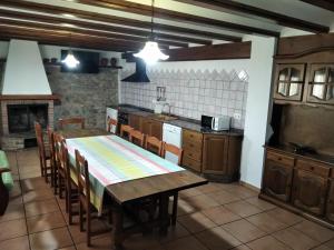 Casa la Cisterna في Pina de Montolgrao: مطبخ مع طاولة وكراسي وموقد