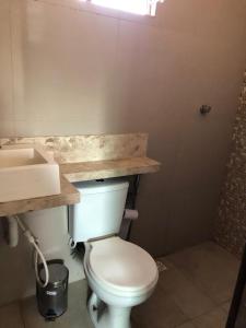 een badkamer met een wit toilet en een wastafel bij Casa e suítes da Vava in Trairi